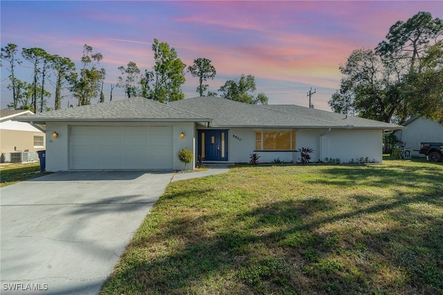 single story home featuring a yard and a garage