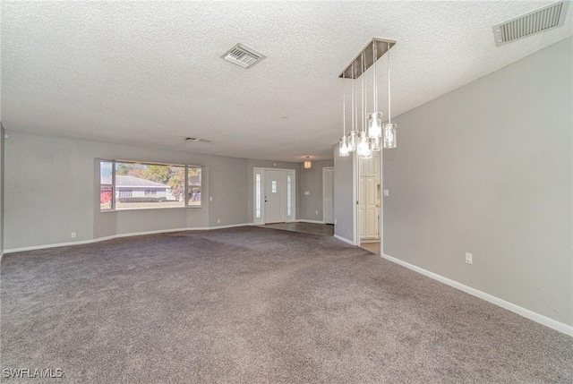 unfurnished room with carpet flooring and a textured ceiling