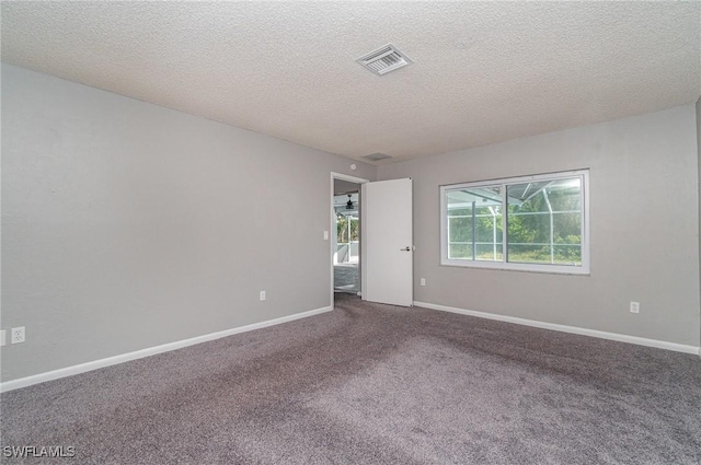 unfurnished room with carpet and a textured ceiling