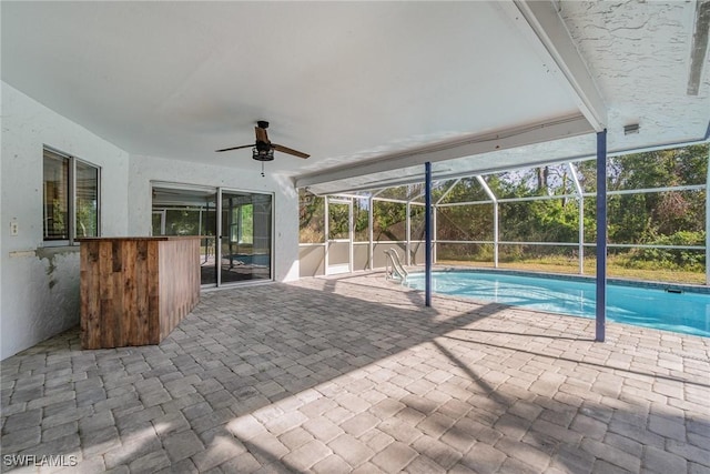 view of swimming pool featuring ceiling fan, a patio area, and glass enclosure