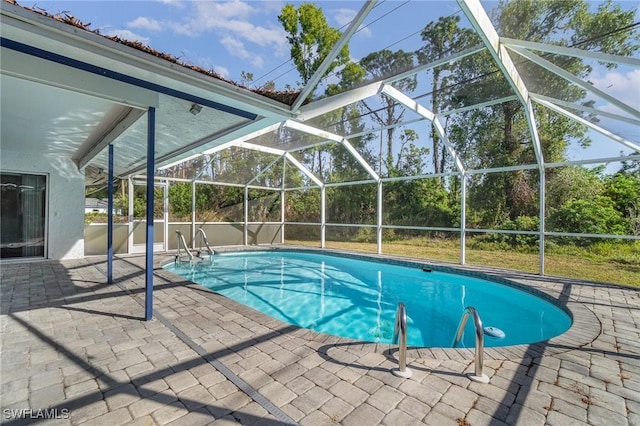 view of swimming pool with glass enclosure and a patio area