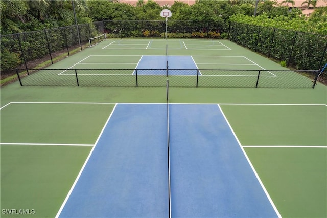 view of tennis court featuring basketball hoop