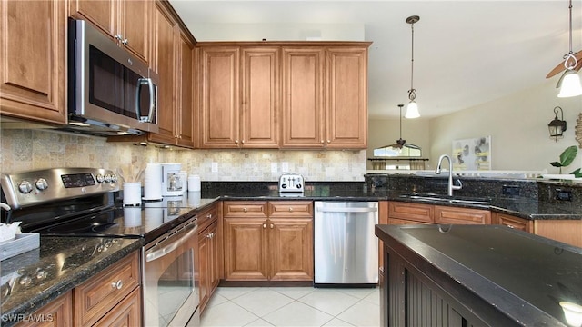 kitchen featuring sink, ceiling fan, appliances with stainless steel finishes, tasteful backsplash, and decorative light fixtures