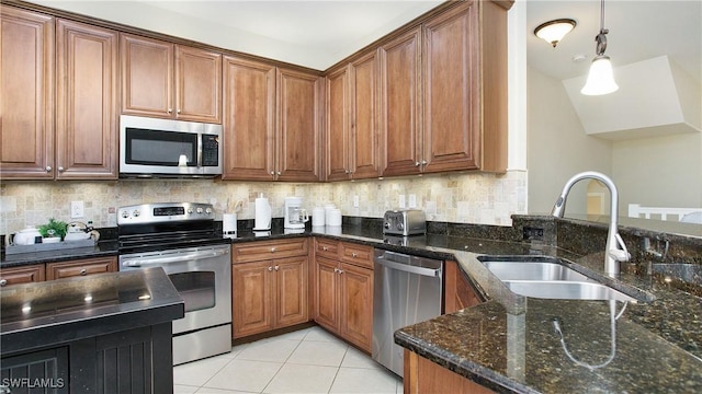 kitchen with decorative backsplash, dark stone countertops, sink, and stainless steel appliances