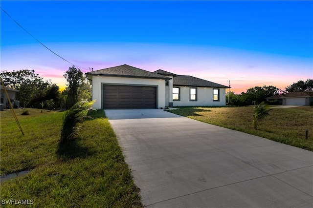 view of front of house featuring a garage and a yard