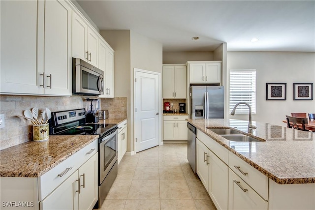 kitchen with a kitchen island with sink, sink, white cabinets, and stainless steel appliances