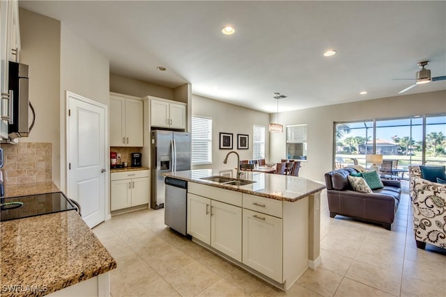 kitchen featuring pendant lighting, an island with sink, stainless steel appliances, and sink