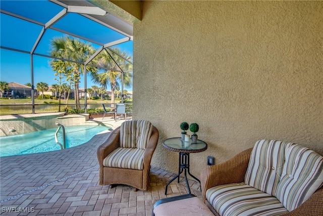 view of pool featuring glass enclosure and a patio