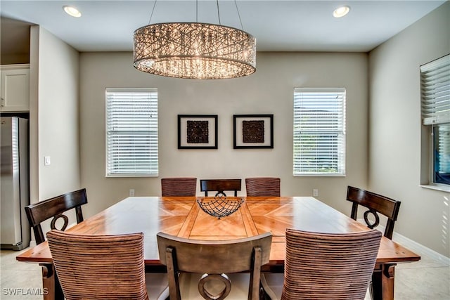 tiled dining room with a wealth of natural light and an inviting chandelier