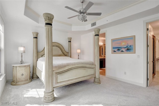 bedroom with ceiling fan, a raised ceiling, ensuite bathroom, light carpet, and ornamental molding