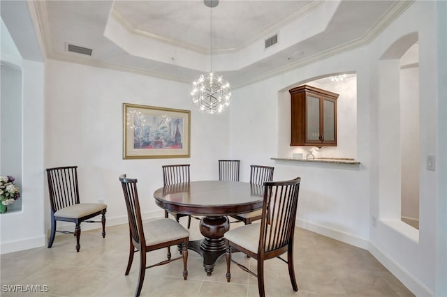 tiled dining space with a chandelier, a tray ceiling, and crown molding