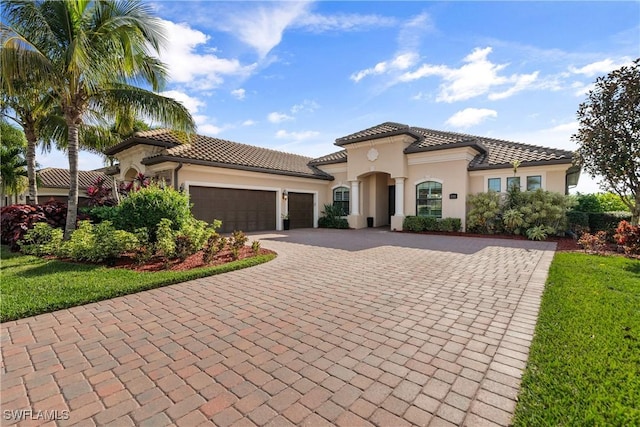 mediterranean / spanish-style home with a front yard and a garage