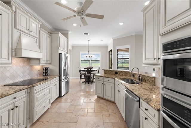 kitchen with white cabinets, sink, appliances with stainless steel finishes, decorative light fixtures, and custom range hood