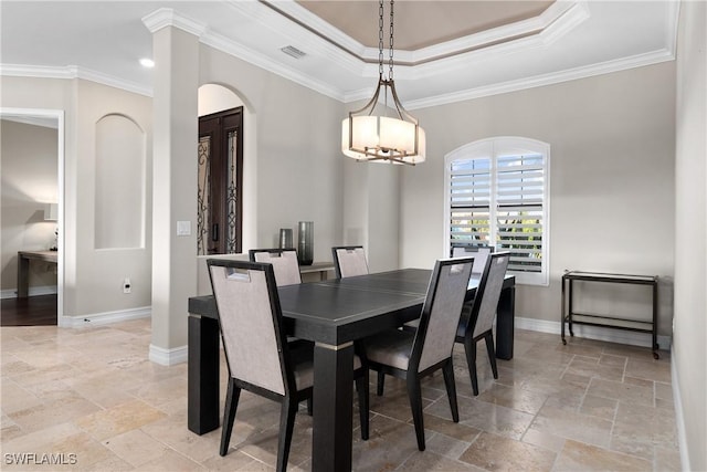 dining space featuring a chandelier, a tray ceiling, and ornamental molding