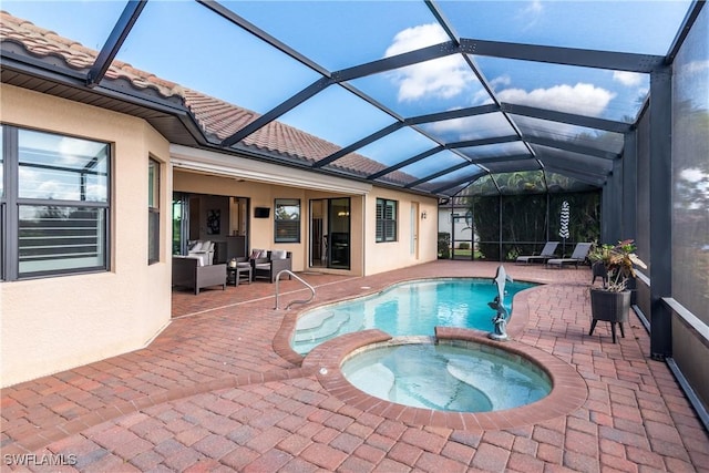 view of pool with an in ground hot tub, outdoor lounge area, a patio, and glass enclosure