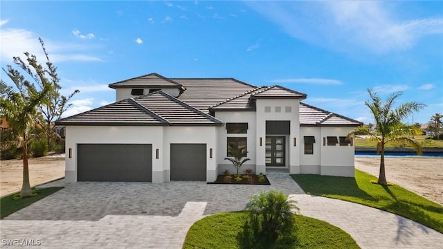 view of front of house with french doors, a water view, and a garage