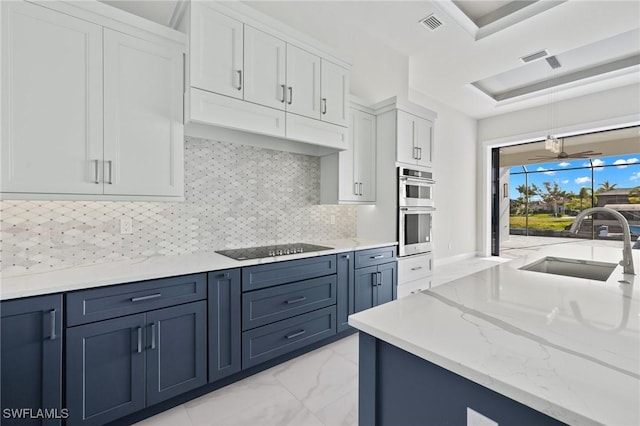 kitchen with black electric stovetop, backsplash, double oven, decorative light fixtures, and white cabinets