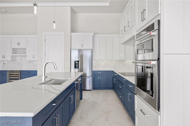 kitchen featuring white cabinetry, sink, stainless steel appliances, blue cabinets, and decorative light fixtures