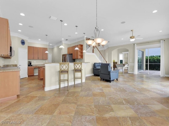 kitchen featuring pendant lighting, ceiling fan, stainless steel fridge, and crown molding