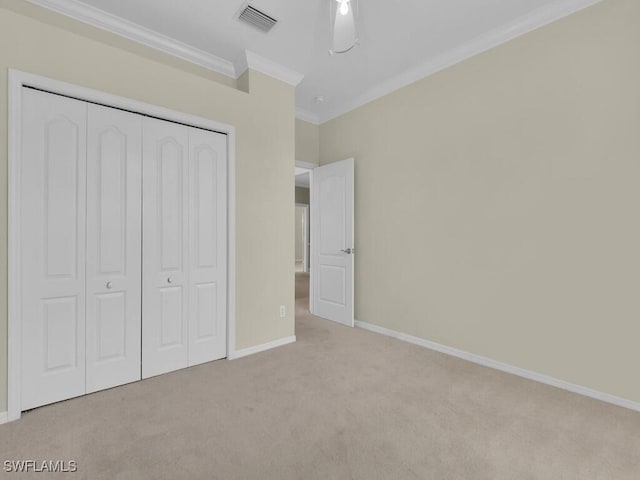 unfurnished bedroom featuring ornamental molding, light carpet, and a closet