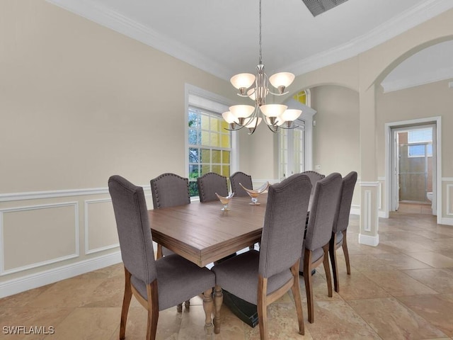 dining room with ornamental molding and an inviting chandelier