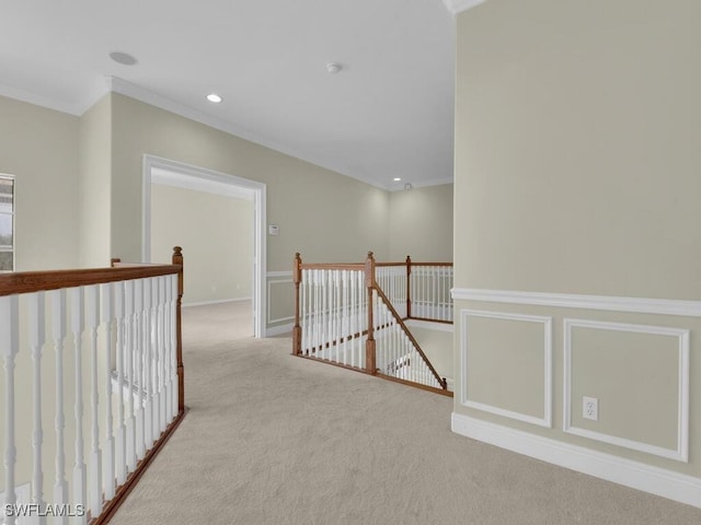 hall with light colored carpet and crown molding