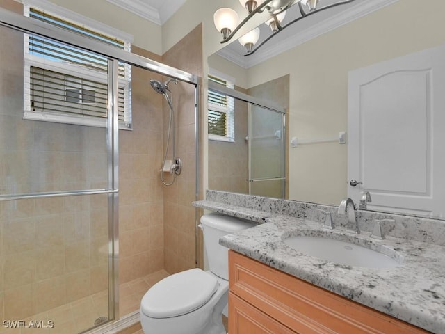 bathroom featuring toilet, a shower with door, vanity, and ornamental molding