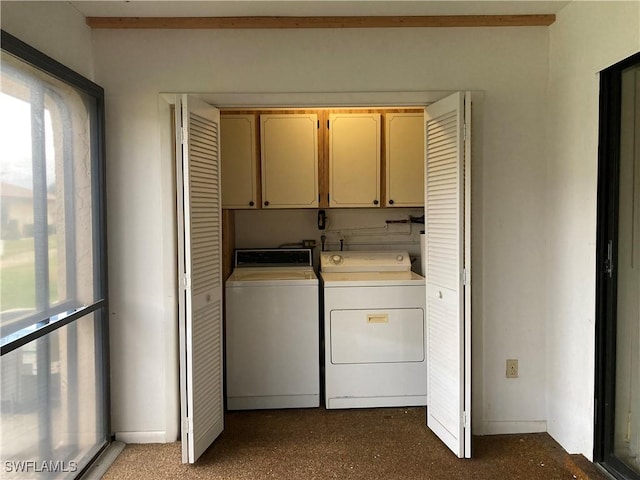 clothes washing area with cabinets and washer and dryer