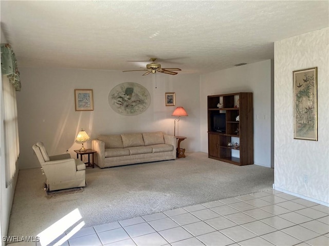 unfurnished living room featuring ceiling fan, light colored carpet, and a textured ceiling