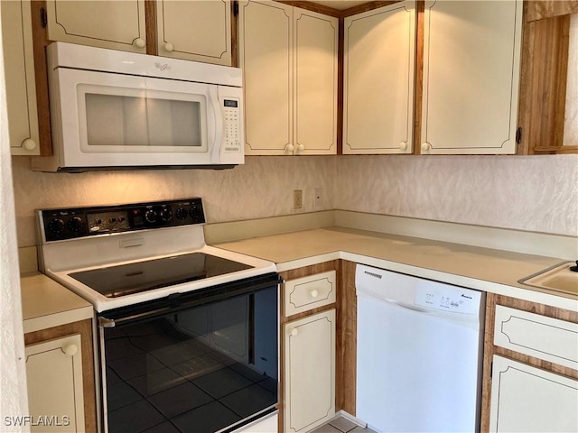 3923 SE 11th Ave Unit 304, Cape Coral, FL 33904 - kitchen featuring white appliances, light countertops, and tile patterned flooring