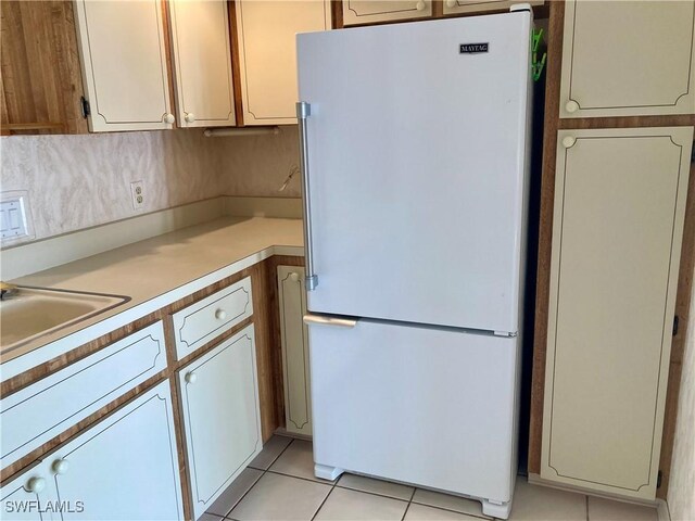 3923 SE 11th Ave Unit 304, Cape Coral, FL 33904 - kitchen featuring freestanding refrigerator, light tile patterned floors, light countertops, and a sink