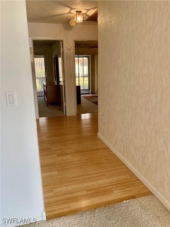 3923 SE 11th Ave Unit 304, Cape Coral, FL 33904 - hallway with healthy amount of natural light, baseboards, and light wood-type flooring
