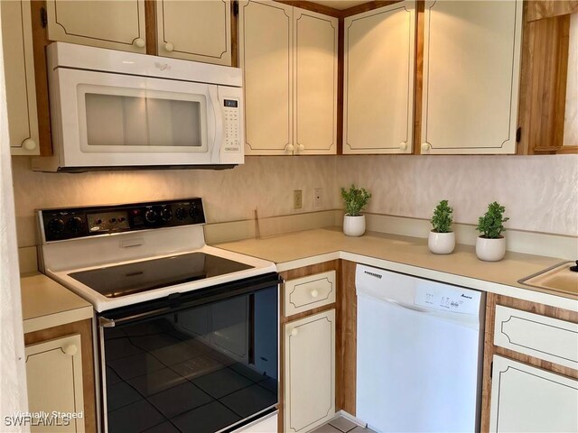 3923 SE 11th Ave Unit 304, Cape Coral, FL 33904 - kitchen with white appliances, light countertops, and tile patterned flooring