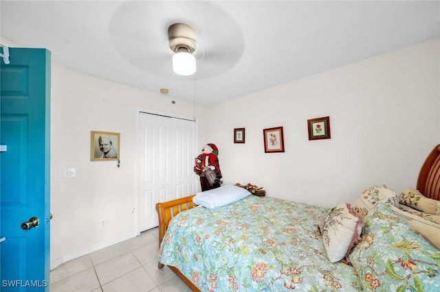 tiled bedroom with ceiling fan and a closet