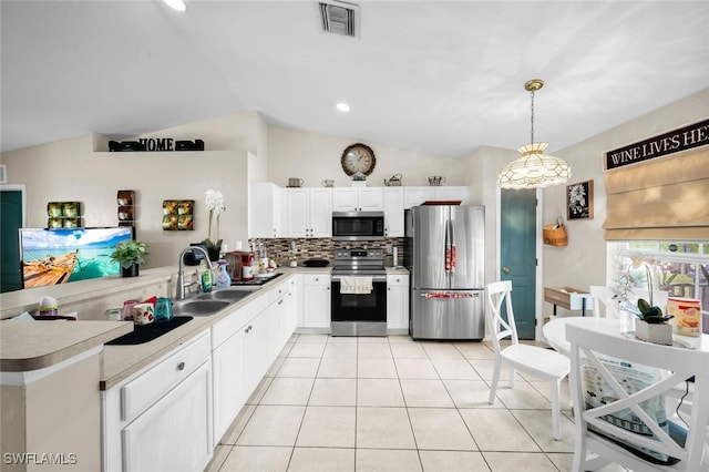 kitchen with lofted ceiling, sink, hanging light fixtures, white cabinetry, and stainless steel appliances