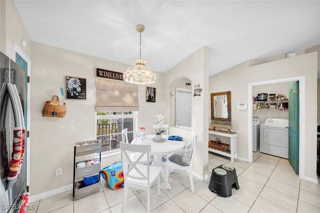 dining space featuring light tile patterned floors, vaulted ceiling, and washing machine and clothes dryer