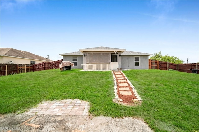 rear view of property featuring a sunroom and a yard