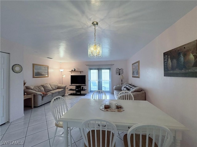 dining room featuring light tile patterned flooring and a notable chandelier