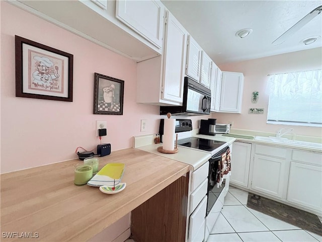 kitchen featuring sink, white cabinets, light tile patterned flooring, and white electric range