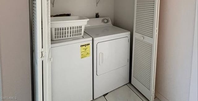 laundry room featuring washer and clothes dryer and light tile patterned flooring