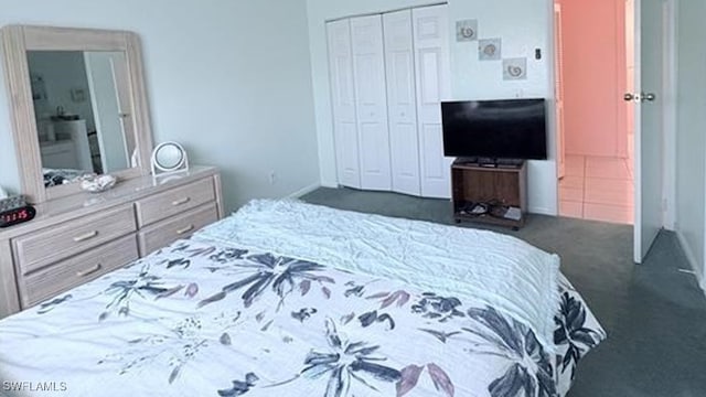 bedroom with dark carpet and a closet