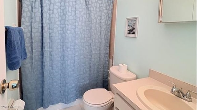 bathroom with a shower with shower curtain, vanity, and toilet