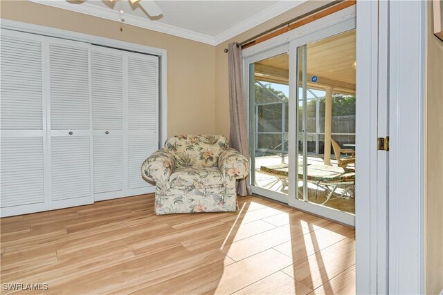 sitting room with light hardwood / wood-style floors, ceiling fan, and ornamental molding