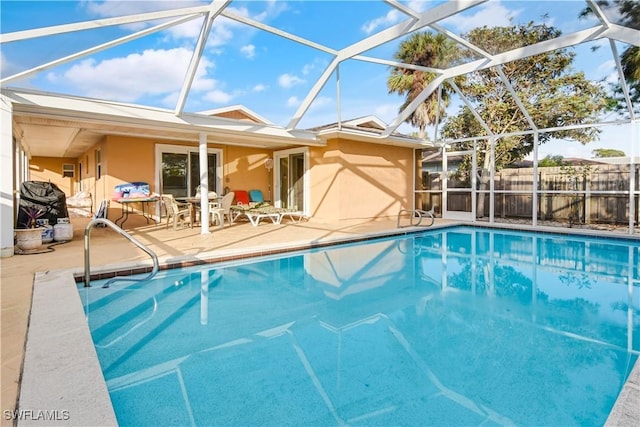 view of swimming pool featuring glass enclosure and a patio