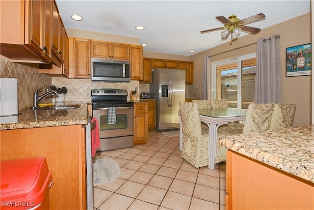 kitchen featuring sink, decorative backsplash, ceiling fan, light tile patterned floors, and stainless steel appliances