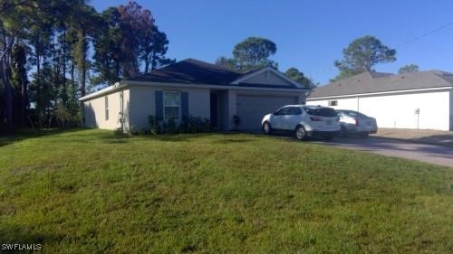 single story home featuring a garage and a front lawn