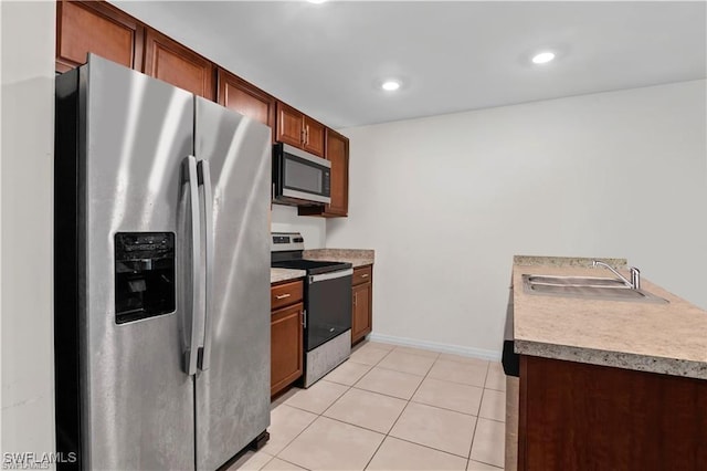 kitchen with sink, light tile patterned floors, and appliances with stainless steel finishes