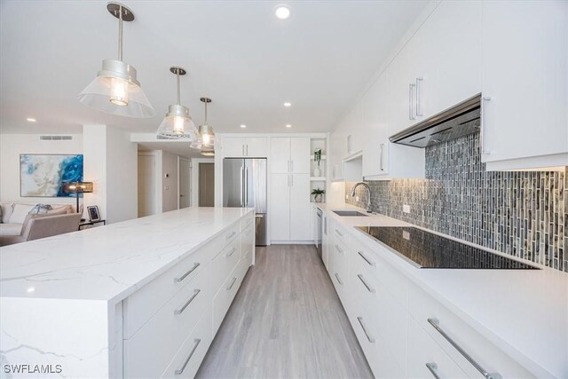 kitchen with stainless steel appliances, ventilation hood, a spacious island, white cabinets, and light wood-type flooring