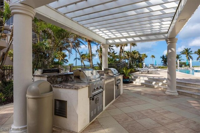 view of patio featuring a pergola, exterior kitchen, and grilling area