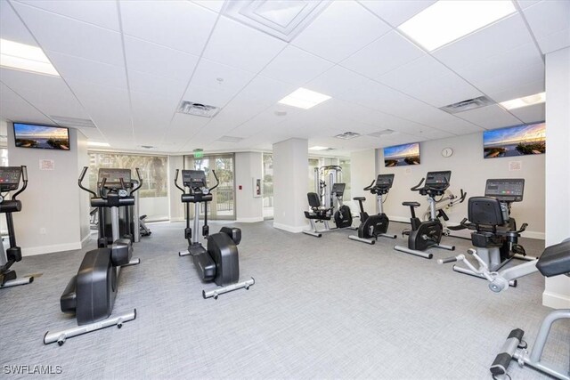 exercise room featuring carpet flooring and a paneled ceiling